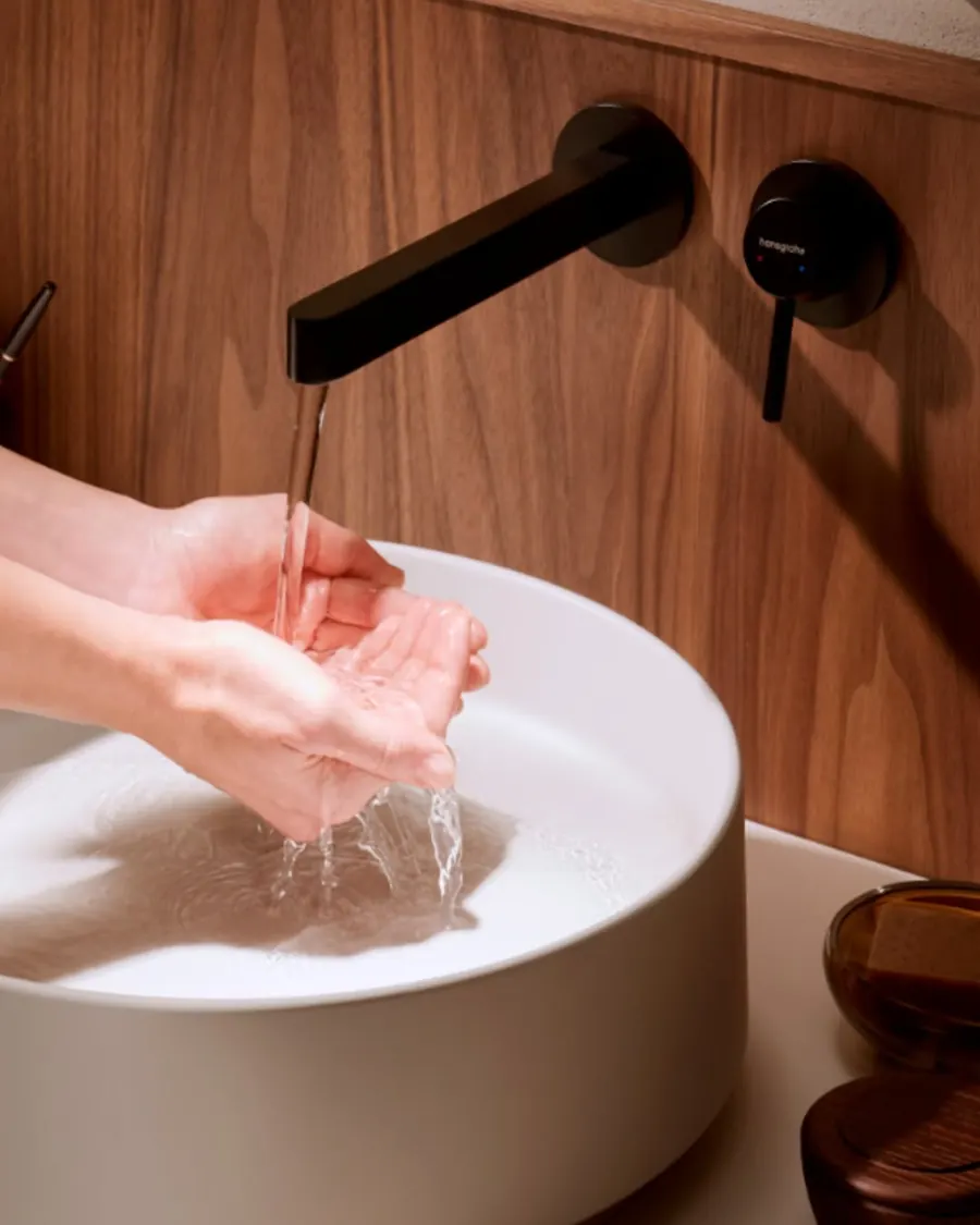 Siyah duvardan lavabo bataryası ve seramik lavabo